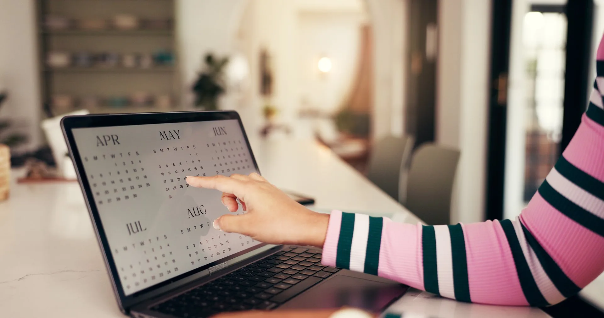 Hands, laptop and point at calendar for remote work from home, schedule and time management for project. Person, computer screen and check date for deadline, planning or reminder for job at apartment